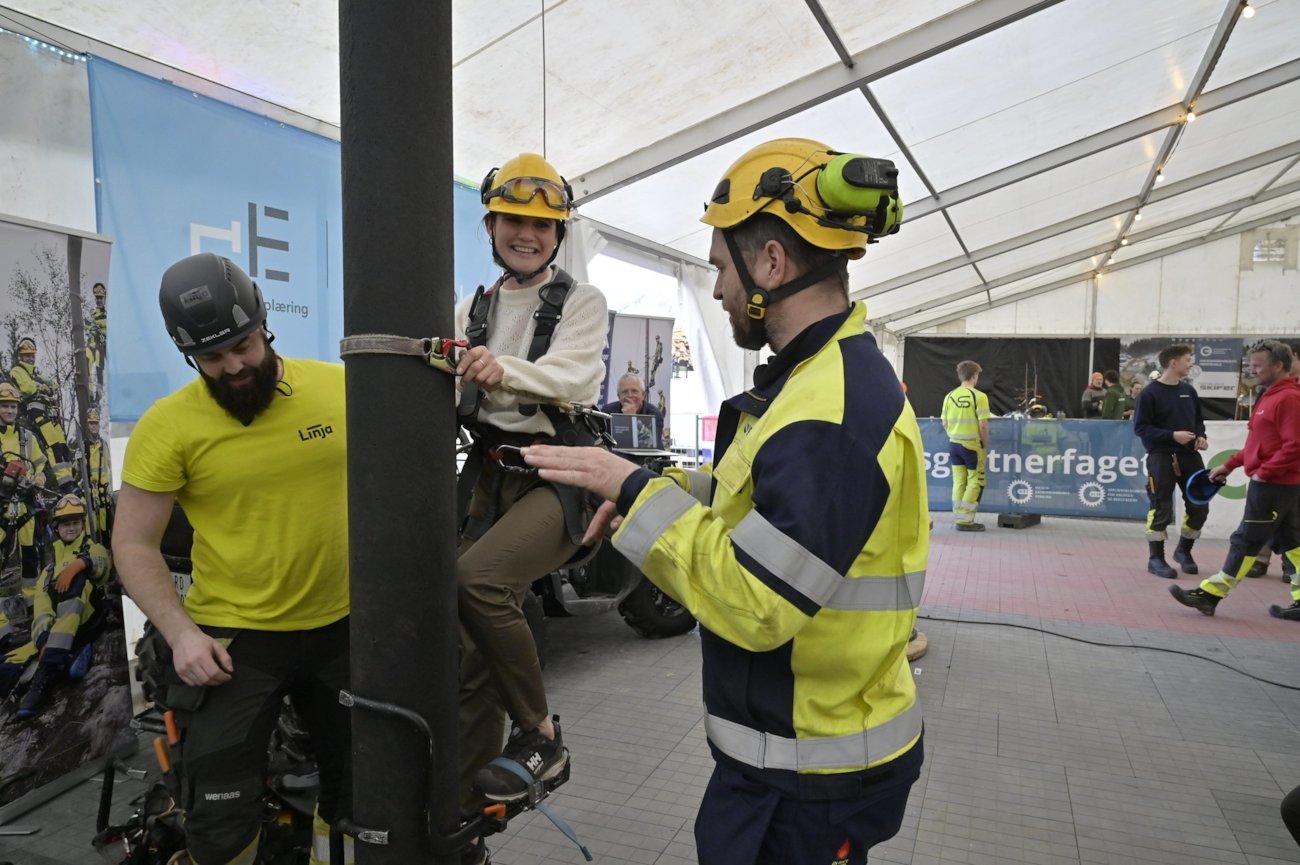 Kunnskapsminister Kara Nessa Nordtun tok utfordringen på strak arm – og testet stolpeklatring på energimontørenes arena under Yrkes-NM i Førde.
